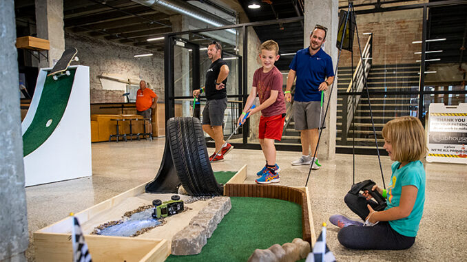 A family enjoys playing micro golf. Accutech employees designed the holes. Photo provided by Accutech