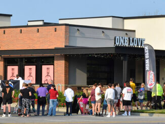 Patrons excited for the opening of Raising Cane's gather at 9am on opening day. Photo by Mike Rhodes