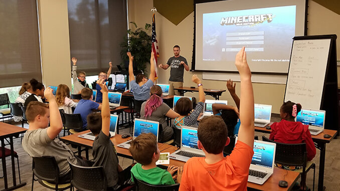 Ryan Hunter, co-founder of TechWise Academy, leads a Minecraft Party in which students get to learn about command blocks and play online in a safe environment. File photo.